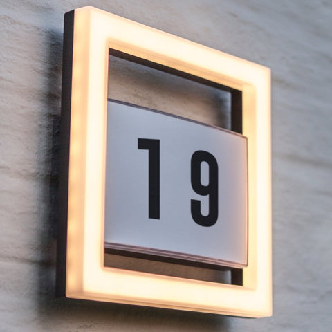 A house number wall light mounted on an outdoor wall.