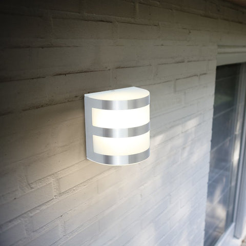 An outdoor wall light with a steel finish mounted on an outdoor wall