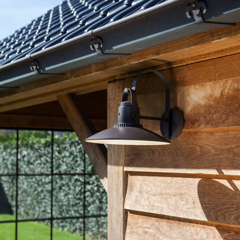 A lamp style outdoor light mounted on a shed wall.