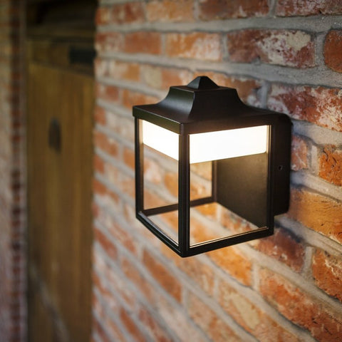 A box outdoor wall light mounted on a brick wall.