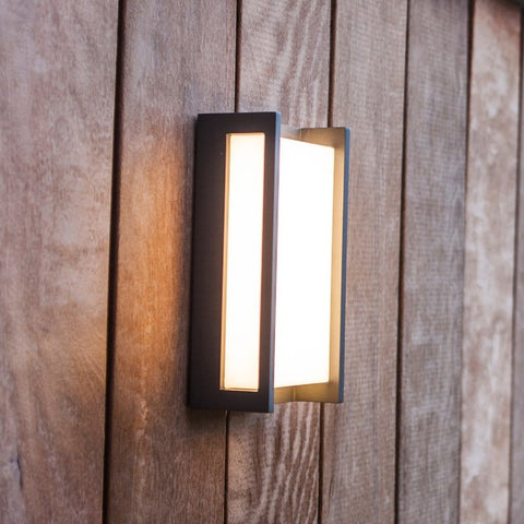 An outdoor wall lighting mounted on wooden paneling.