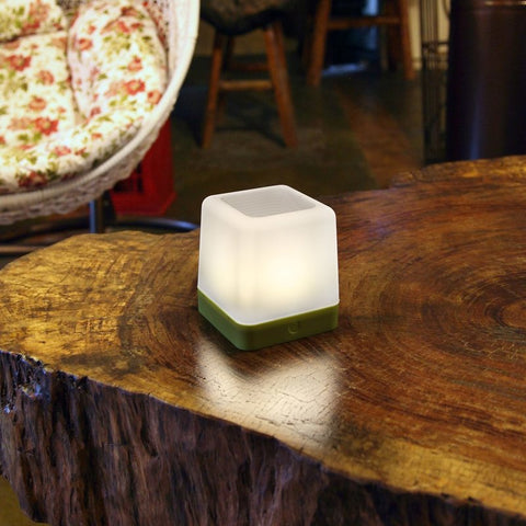 A solar garden light on a wooden stump.