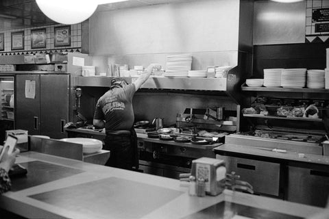 Restaurant kitchen with chef in greyscale