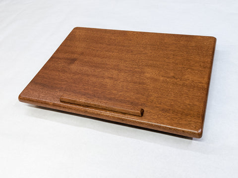 A wooden lap desk with lip for pencils
