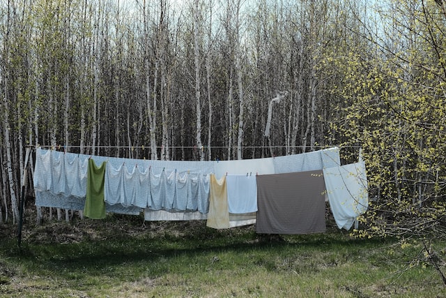 vasketøj der hænger udenfor på tørresnor og lufttørrer i i naturen for at spare penge på strøm når man vasker tøj