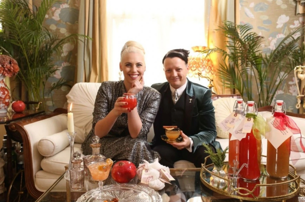 two women with cocktails around them sitting on a couch