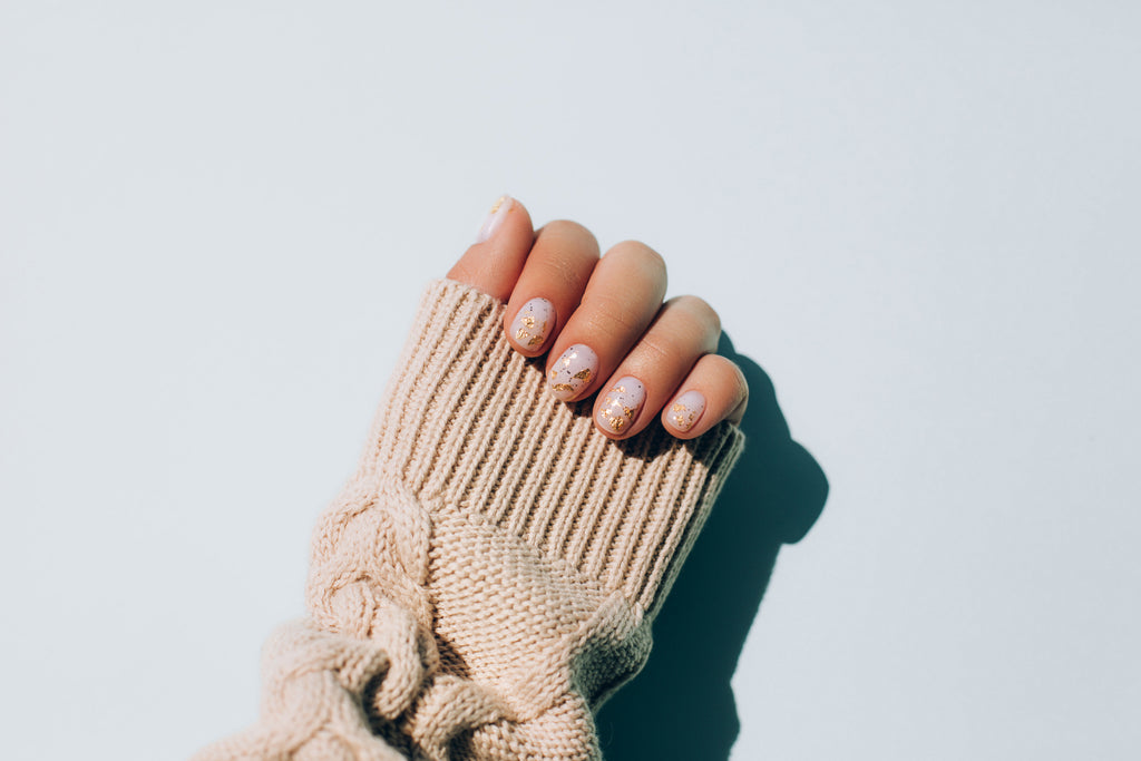 Woman’s hand in a warm sweater showing manicure