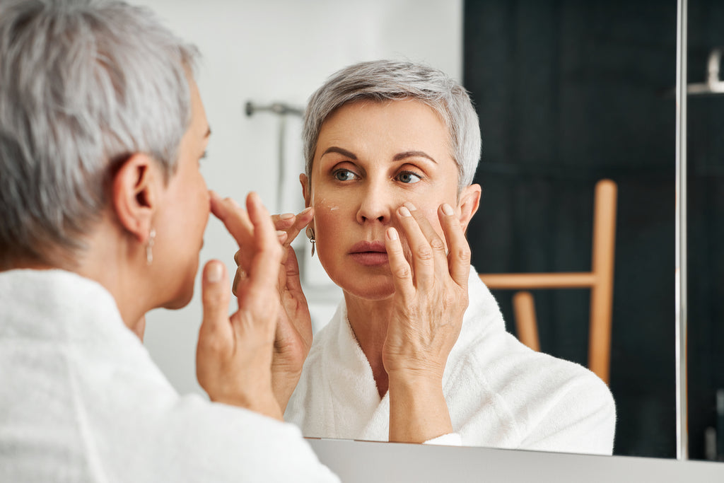 Older woman applying hyaluronic acid serum 