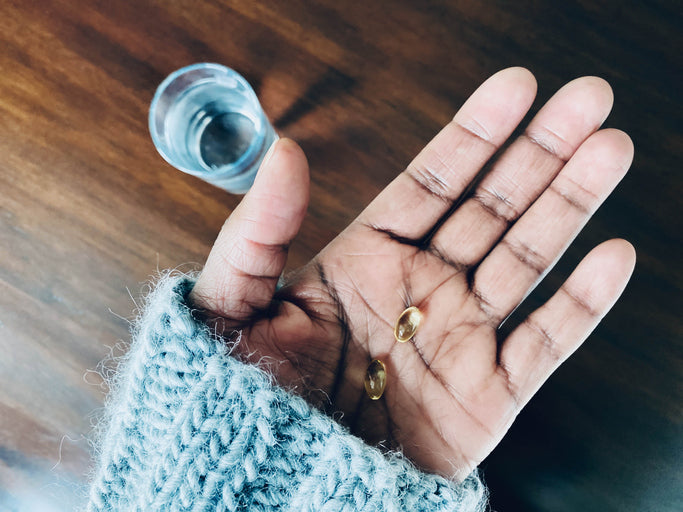 Woman holds Vitamin D capsules