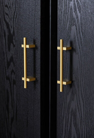 gold cabinet handles on a black cabinet