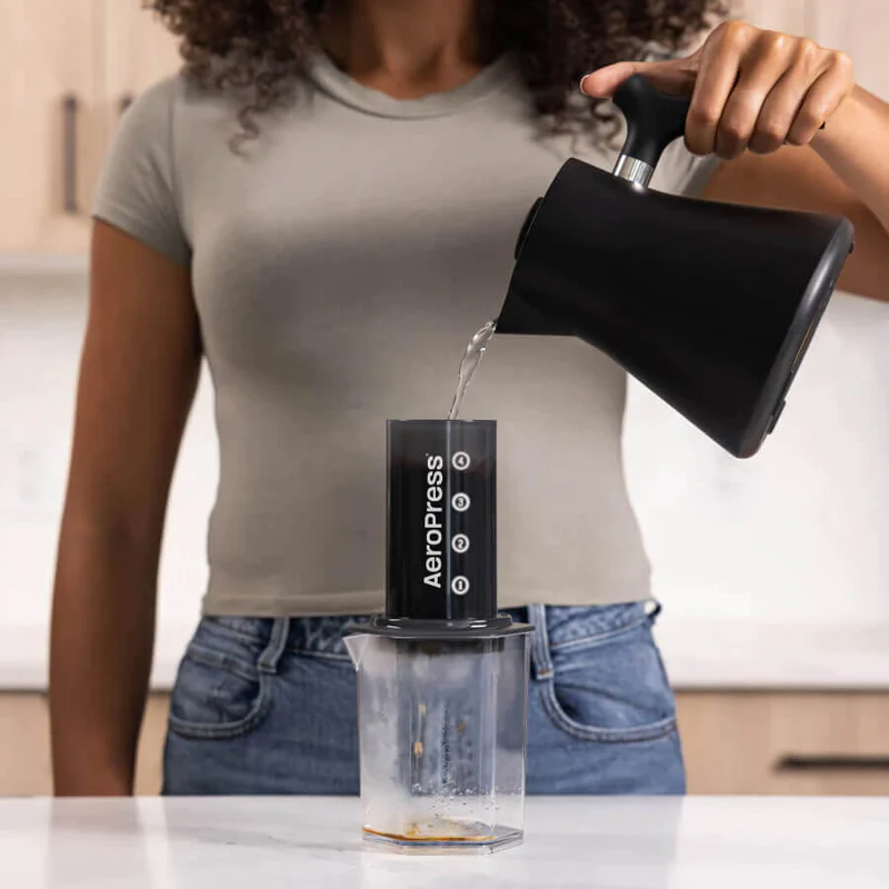 AeroPress Carafe with AeroPress Original coffee maker and woman pouring water