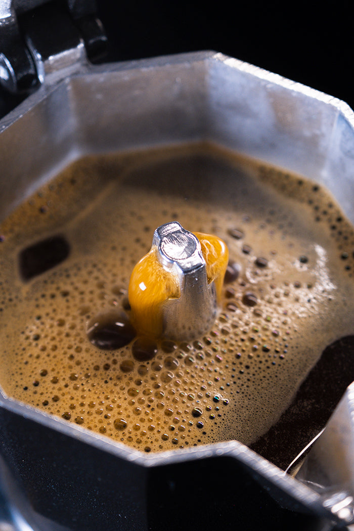 Interior of Moka pot brewing with bubbling coffee