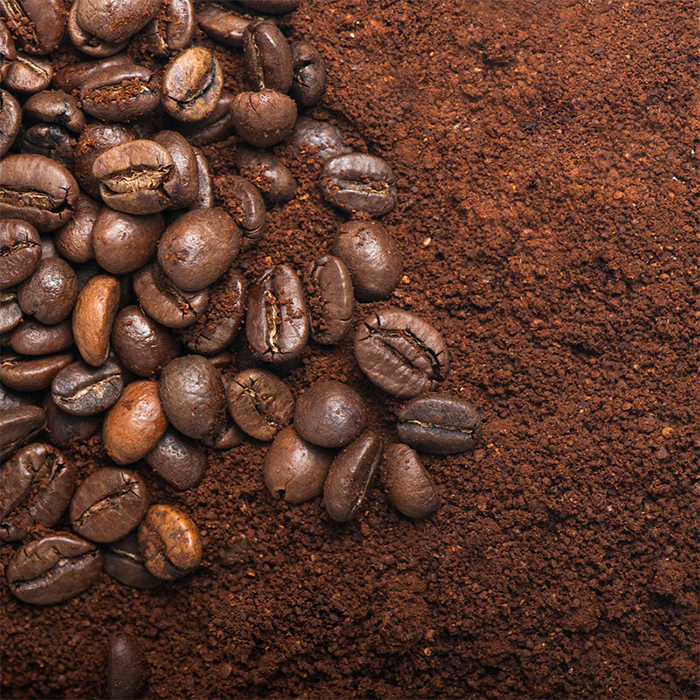 Ground coffee next to whole coffee beans