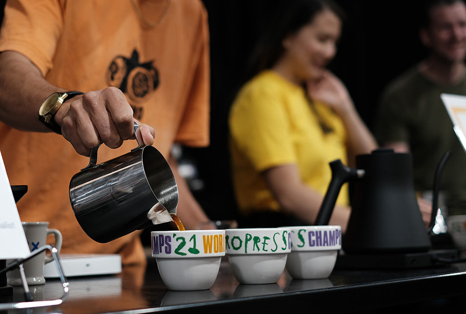 Pouring brewed coffee into 2021 WAC mugs