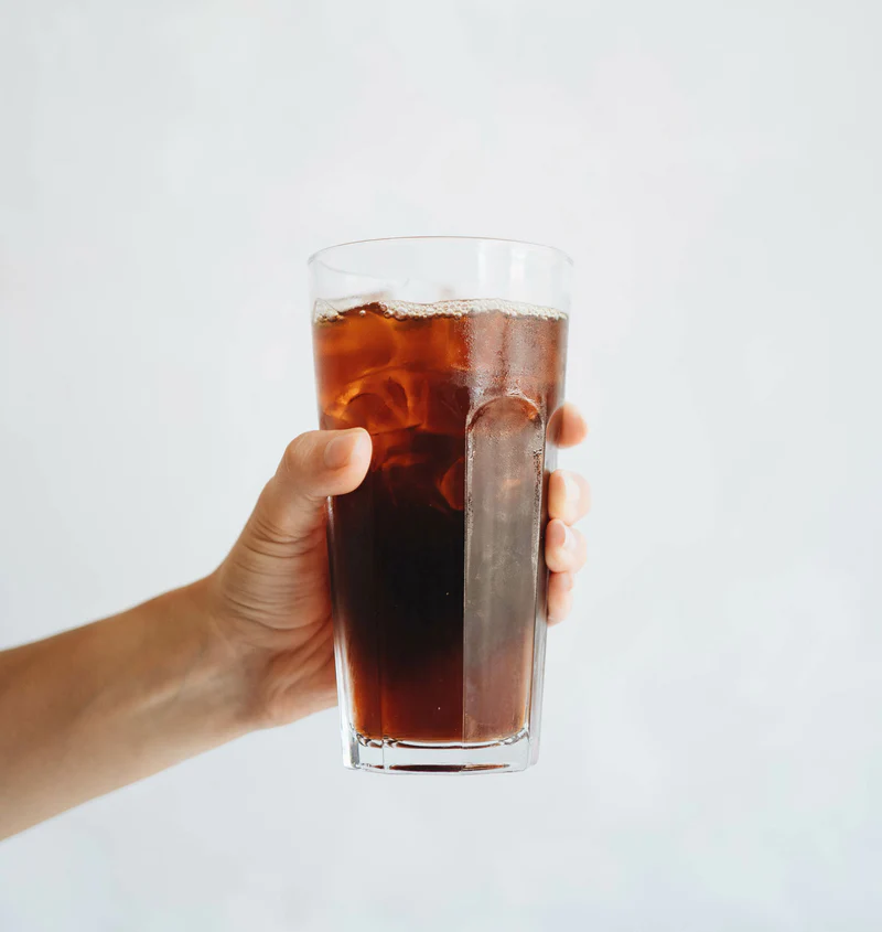 Hand holding up glass full of iced coffee