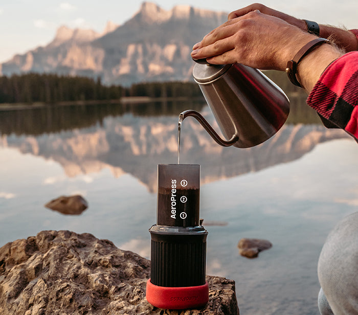 Pouring water into AeroPress Go by lake