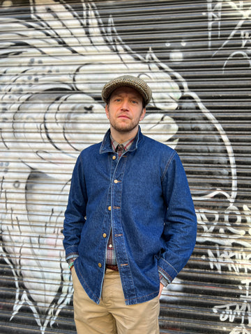 picture of George Russo in a denim shirt and flat cap