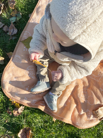 toddler outdoors with blanket