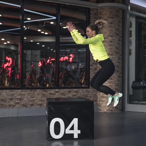 Woman practicing jumps. CrossFit box