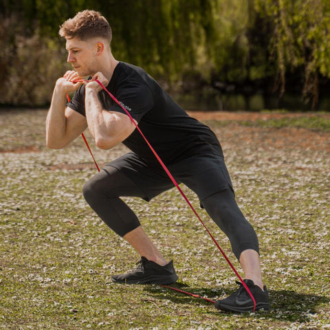 Man exercising outdoors with 3DActive Red Resistance Band