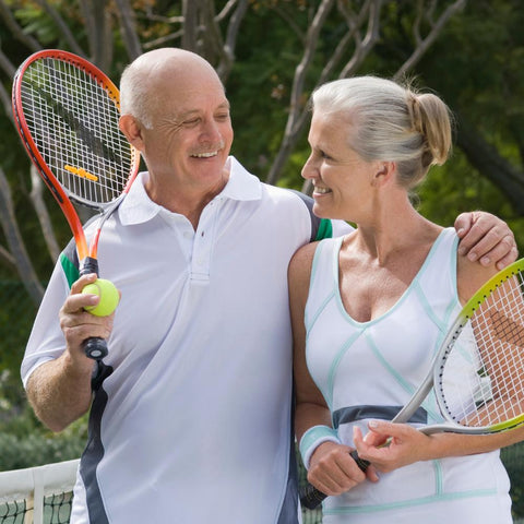 Older couple in tennis clothes embracing each other