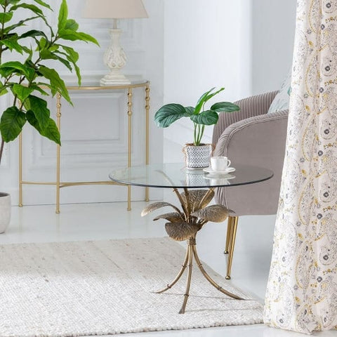 Mesa auxiliar de hojas doradas en una sala de estar contemporánea