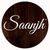 Saanjh Trade Mark Logo Brown Background White Text with small TM mark at top in brown wood finish circle