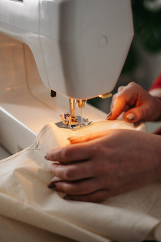 Local tailor Making wedding outfit on white sewing machine with both hands