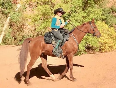 Terry Bannister riding her endurance horse along a trail in a Freeform treeless saddle.