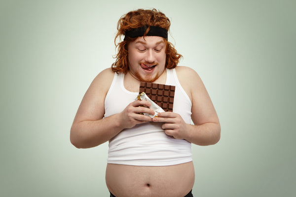 personne obèse avec une tablette de chocolat