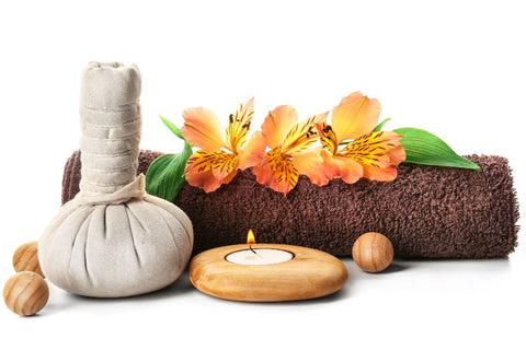 natural hot compress next to a candle and decorative log