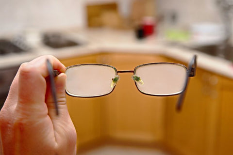 fogged up glasses held in hand