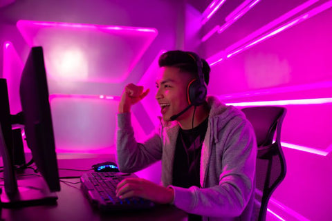 gamer in front of setup with pink neon lights