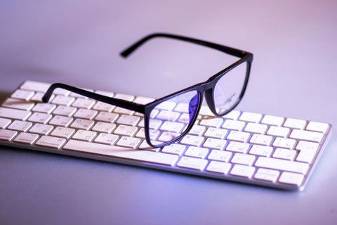 blue light gaming glasses sat on keyboard