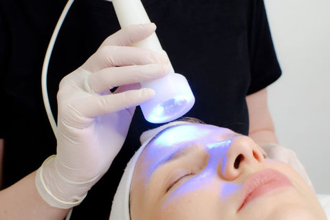 blue light therapy device on woman's forehead