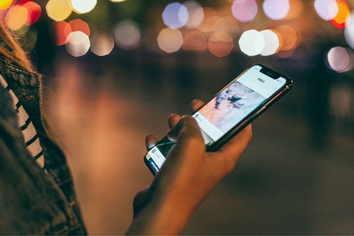 woman holding phone exposed to blue light