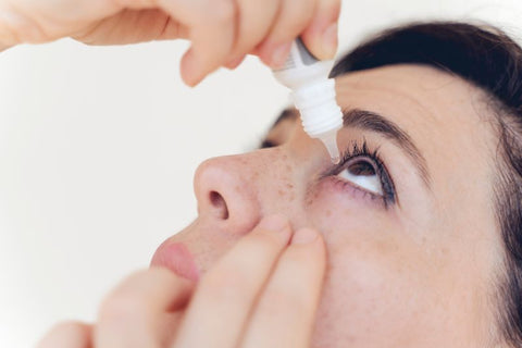 woman using eye drops to relieve irritation