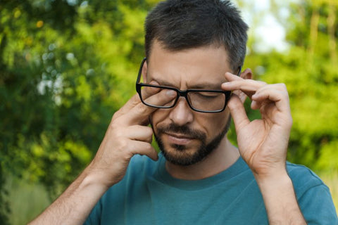 man rubbing dust from his eye