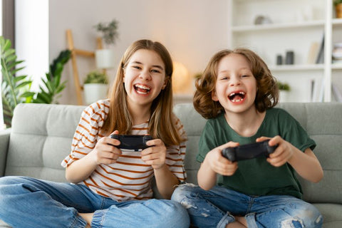 two children playing video games smiling