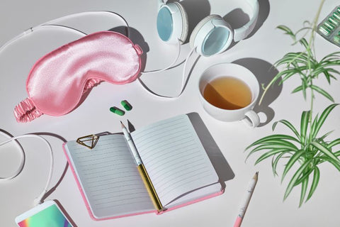 image of a diary cup of tea and sleep mask, all accessories for better sleep