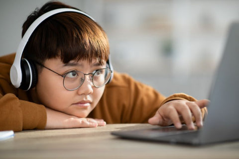 niño con gafas que bloquean la luz azul en la computadora