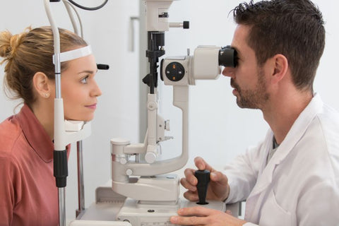 optician checking lady whose eye is twitching