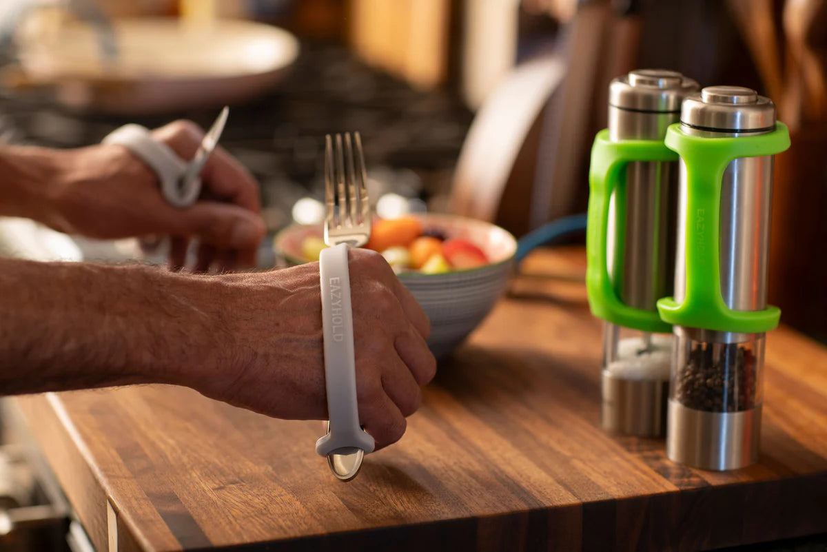 Grandpa holding utensils using EaZyHold grip aids.