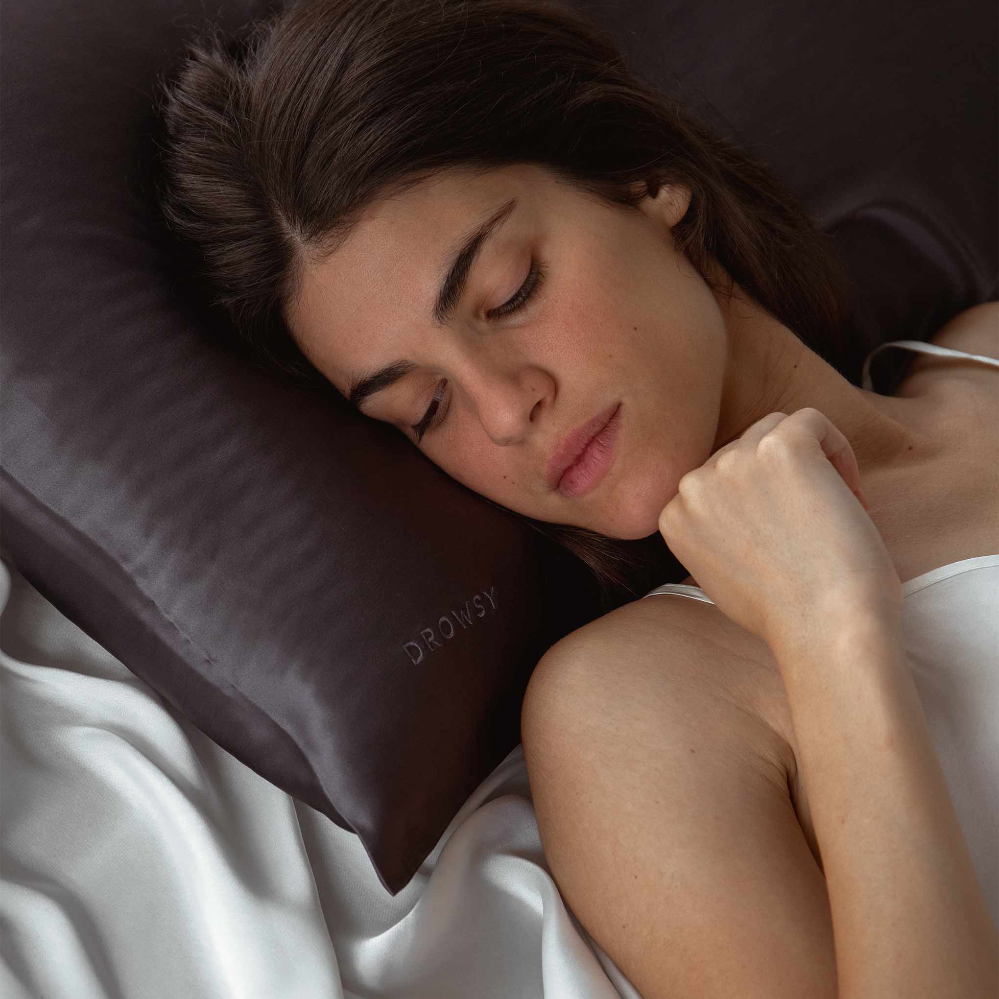 Female sleeping on charcoal coloured Drowsy Silk Pillowcase