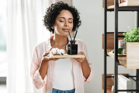 woman with aroma reed diffuser and cotton at home