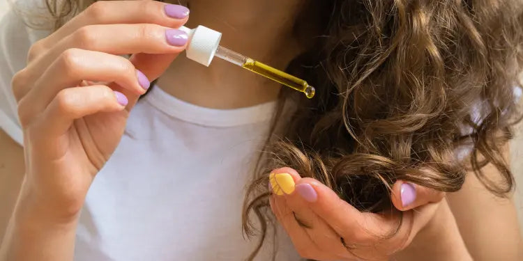 woman dripping hair growth oil onto her hand
