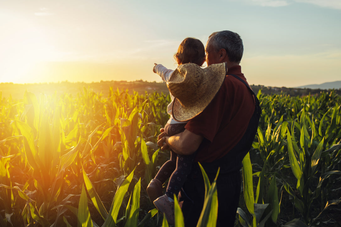 adult and child in field of crops