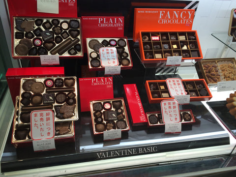 An array of premium Honmei chocolate boxes in a Japanese chocolate store.