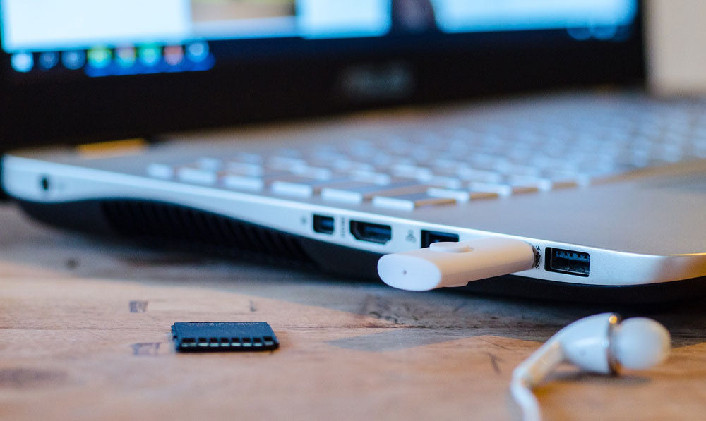 Laptop sitting on a wooden desk with USB plugged in