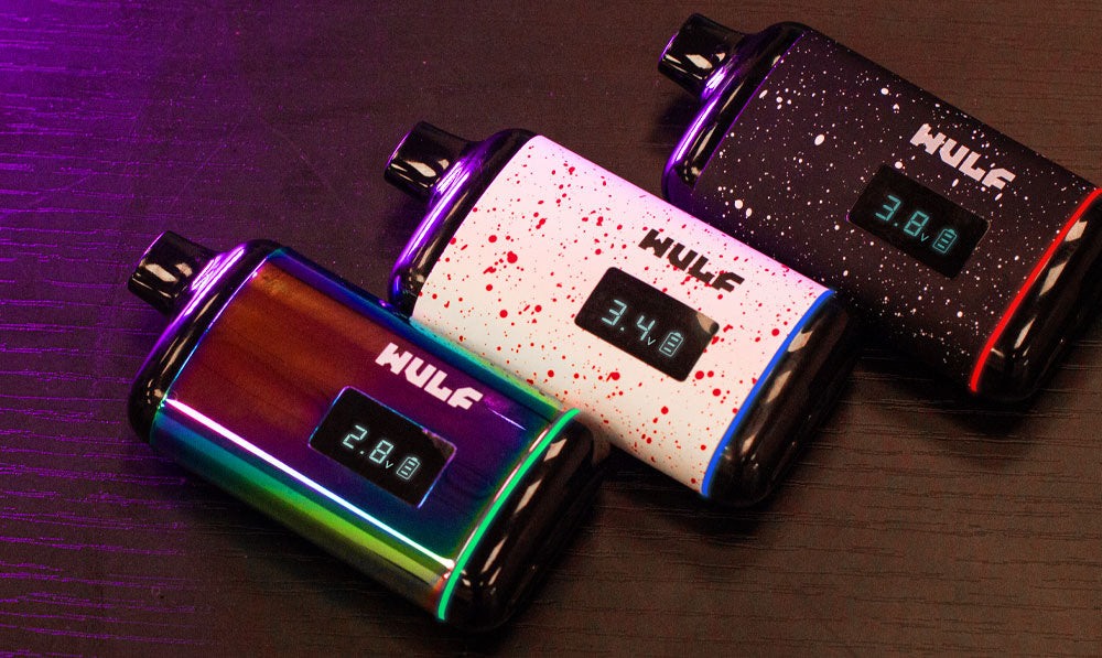 Wulf Recon vaporizers resting on table with soft purple lighting